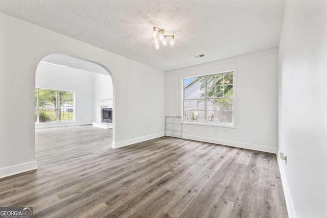 unfurnished room featuring hardwood / wood-style flooring and a textured ceiling