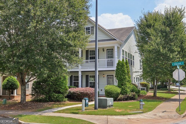 view of front of house featuring a balcony and a front yard