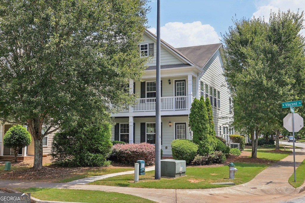 view of front of house featuring a balcony and a front yard