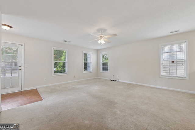 empty room featuring light colored carpet and ceiling fan