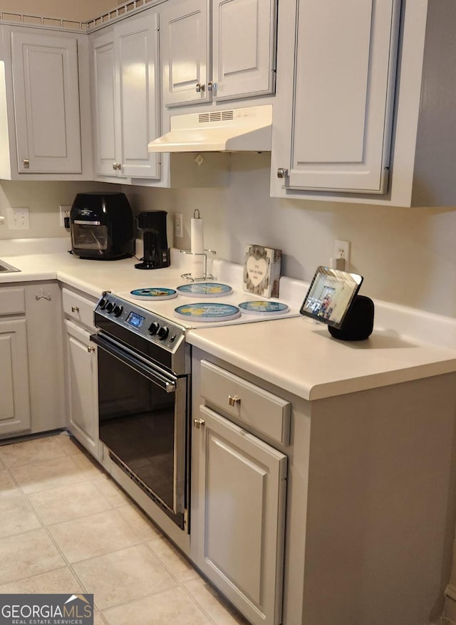 kitchen featuring gray cabinets, stainless steel electric range oven, and light tile patterned floors