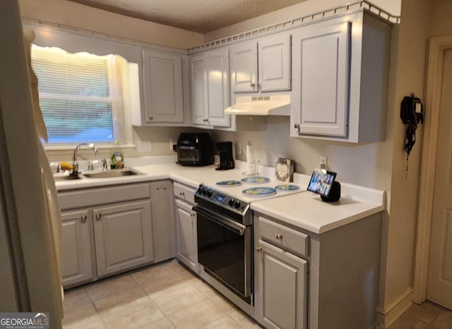 kitchen with gray cabinets, stainless steel range with electric cooktop, sink, and light tile patterned flooring