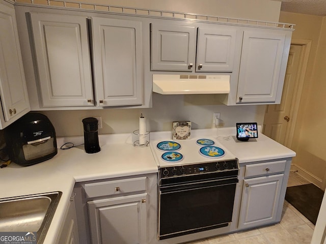 kitchen with electric range oven, sink, and light tile patterned floors