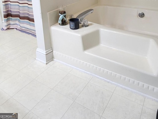 bathroom with a tub to relax in and tile patterned flooring