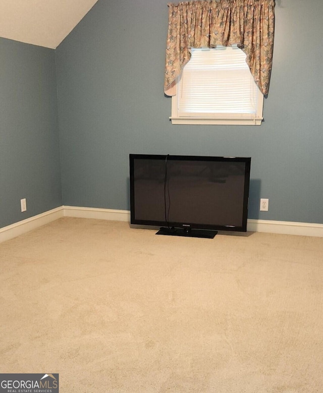 carpeted empty room with lofted ceiling