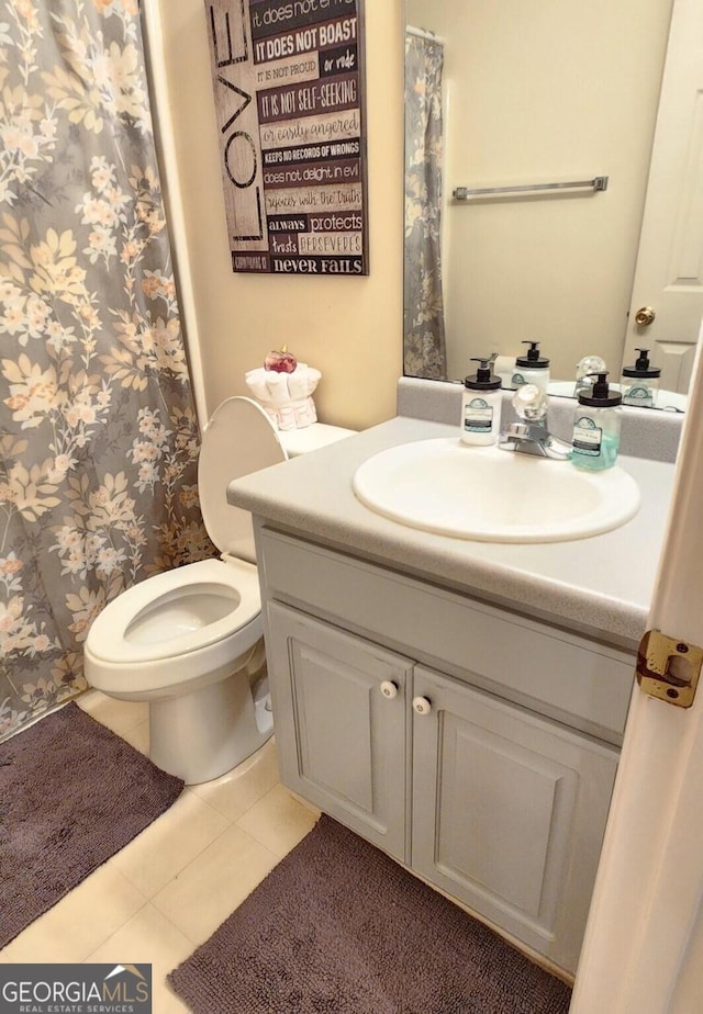 bathroom with tile patterned flooring, vanity, and toilet