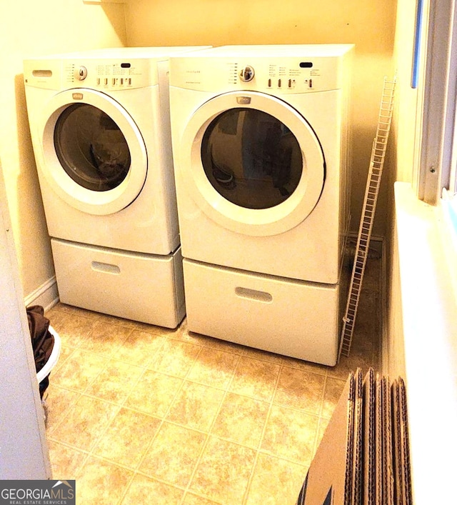 clothes washing area with light tile patterned flooring and washer and dryer