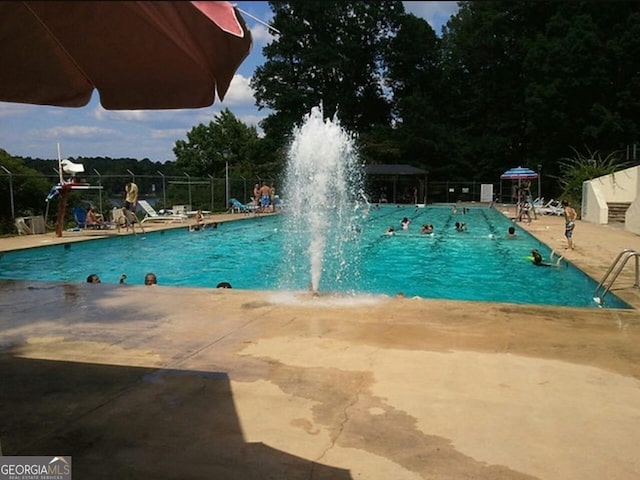 view of swimming pool with pool water feature