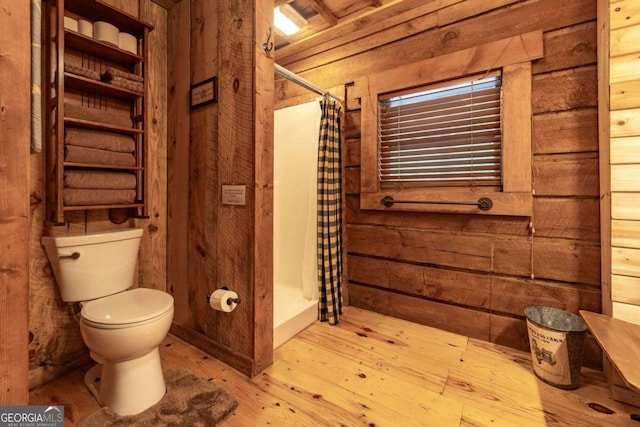 bathroom with wood walls, toilet, hardwood / wood-style floors, and walk in shower