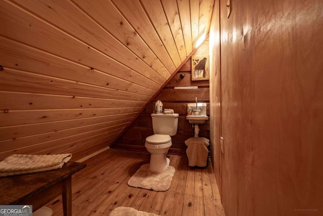 interior space featuring wood walls, hardwood / wood-style flooring, wooden ceiling, toilet, and lofted ceiling