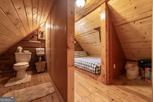 bedroom with light wood-type flooring, lofted ceiling, wooden walls, and wooden ceiling