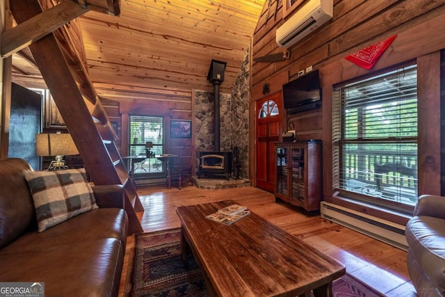 dining room featuring wood walls, a baseboard radiator, a wood stove, wood-type flooring, and wooden ceiling