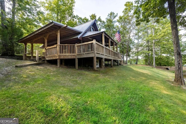 rear view of property featuring a wooden deck and a yard