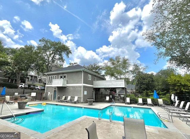 pool featuring fence and a patio