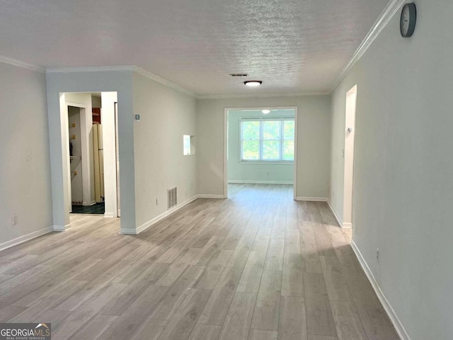 interior space with visible vents, light wood-style flooring, ornamental molding, a textured ceiling, and baseboards