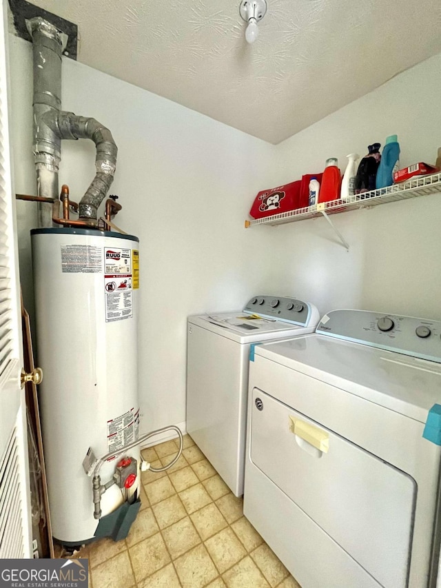 washroom featuring laundry area, water heater, independent washer and dryer, and a textured ceiling