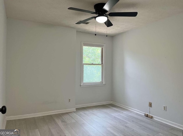 unfurnished room featuring light wood-type flooring, a ceiling fan, baseboards, and a textured ceiling