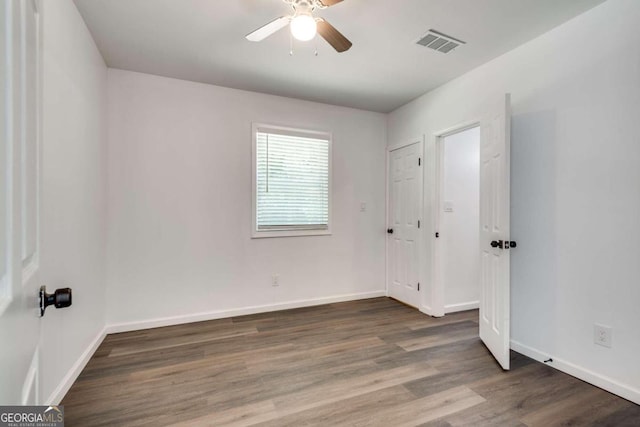 unfurnished bedroom with ceiling fan and wood-type flooring