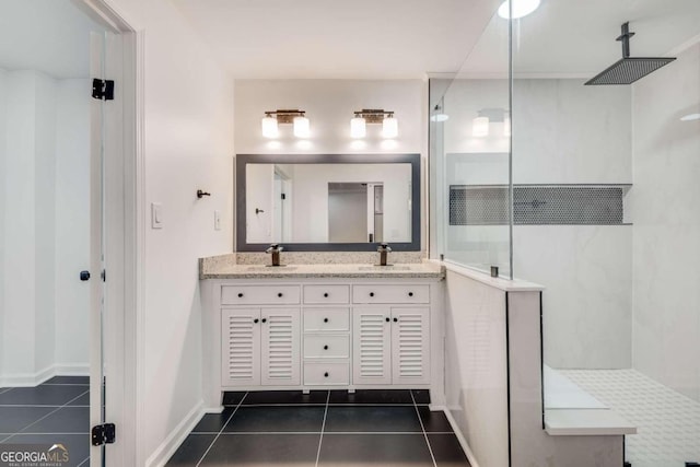 bathroom featuring tiled shower, dual bowl vanity, and tile patterned floors