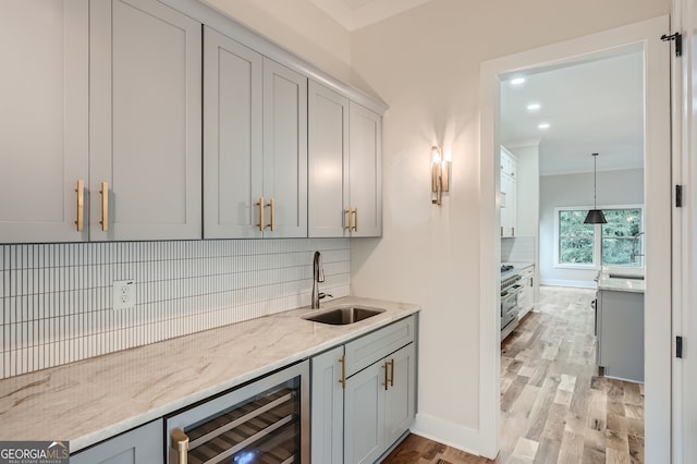 kitchen with sink, decorative backsplash, light wood-type flooring, and wine cooler