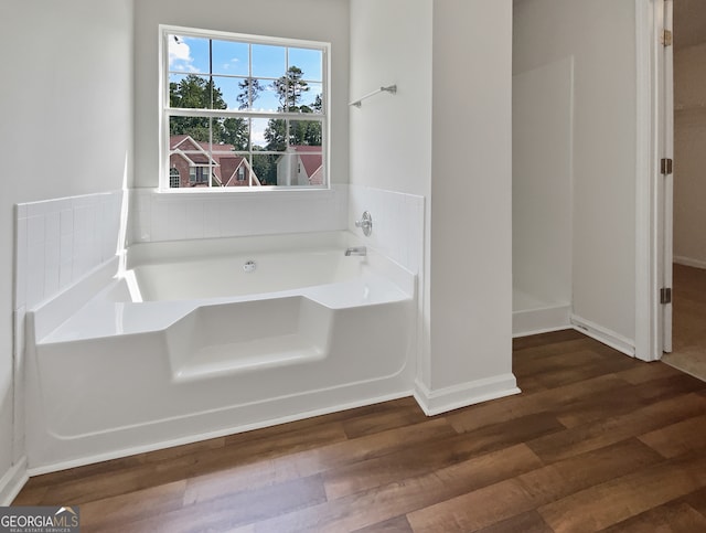 bathroom featuring wood-type flooring and a tub