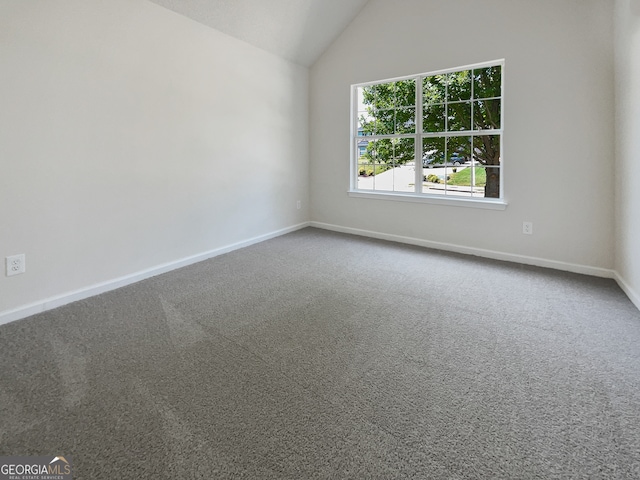 carpeted spare room with vaulted ceiling