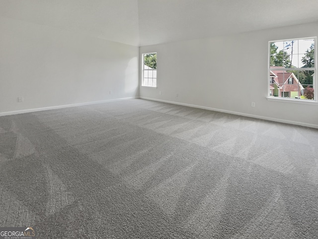 empty room featuring baseboards and carpet flooring