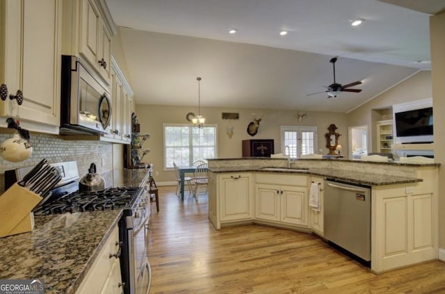 kitchen featuring sink, appliances with stainless steel finishes, cream cabinets, and hanging light fixtures