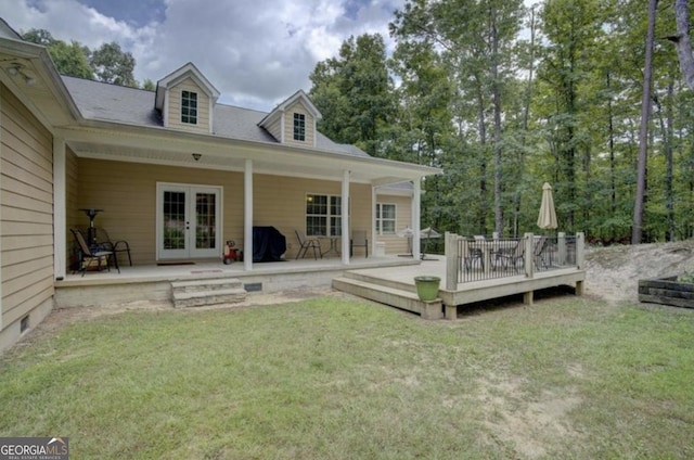 back of property featuring a deck, french doors, and a lawn