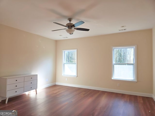 unfurnished bedroom with a ceiling fan, visible vents, wood finished floors, and baseboards