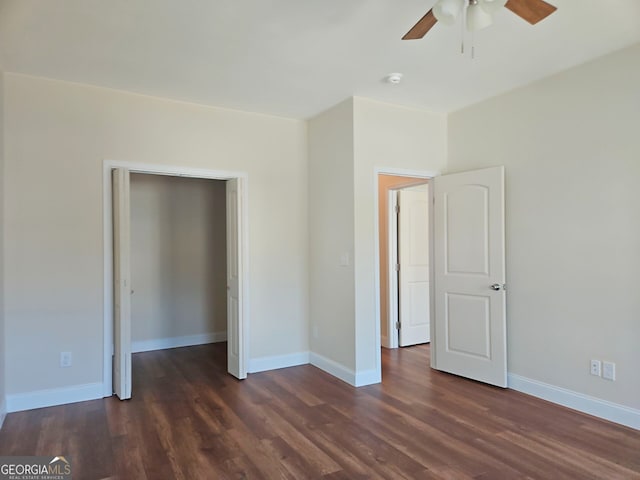 unfurnished bedroom with a ceiling fan, dark wood-type flooring, and baseboards