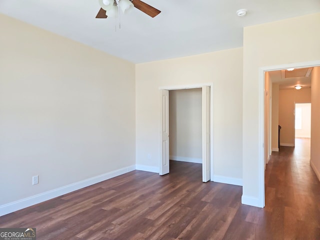 unfurnished bedroom with ceiling fan, dark wood-type flooring, and baseboards