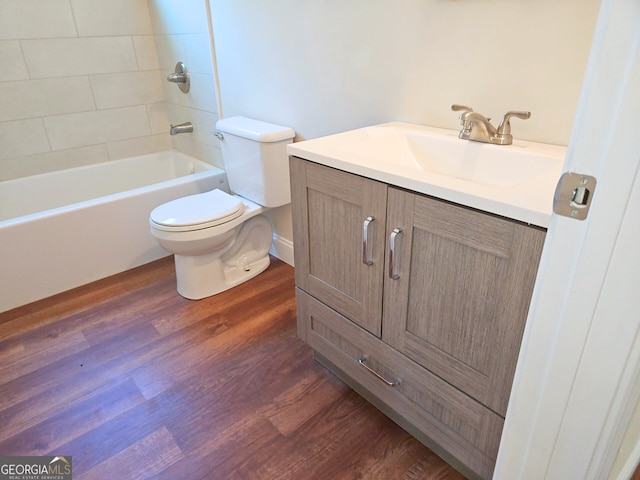 full bath with bathtub / shower combination, toilet, wood finished floors, and vanity