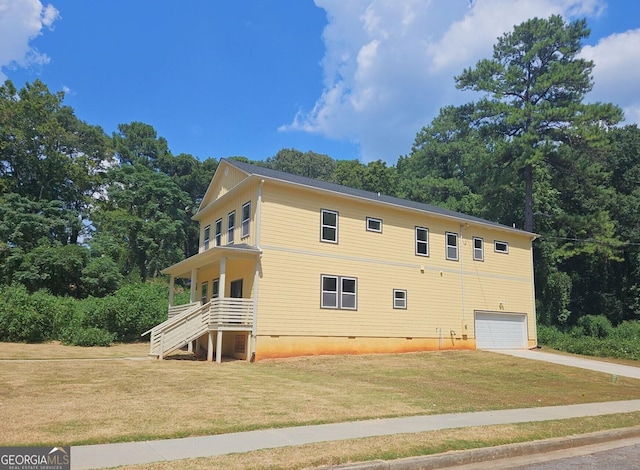 view of property exterior featuring crawl space, a yard, a garage, and concrete driveway