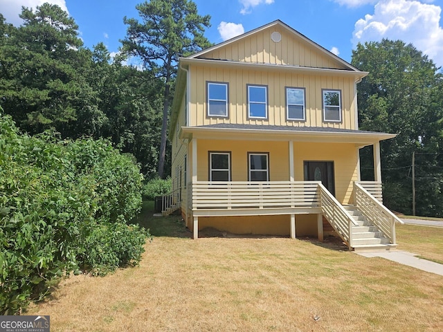 view of front of property with stairway, board and batten siding, covered porch, and a front yard