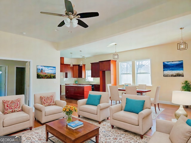 living room with ceiling fan, sink, and light hardwood / wood-style flooring