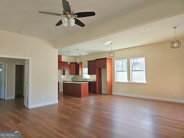 kitchen with backsplash, dark wood finished floors, open floor plan, a center island, and ceiling fan