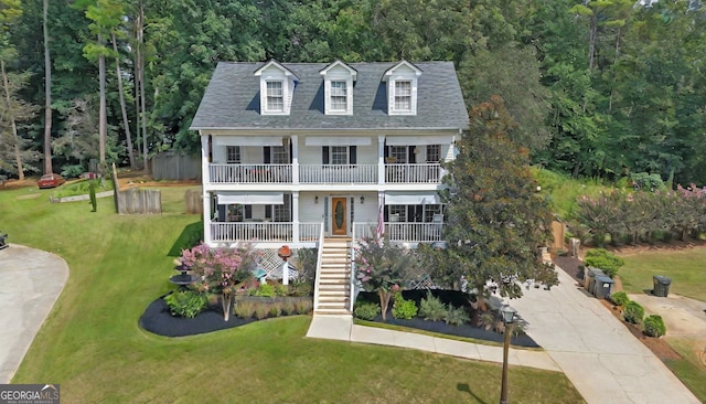 view of front of property featuring a balcony and a front lawn