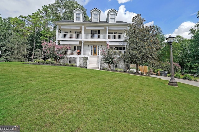 view of front of house with a front lawn and a balcony