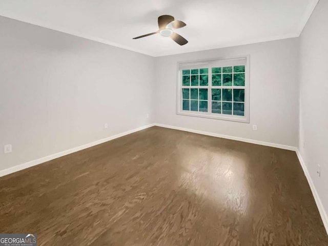 unfurnished room with ceiling fan, crown molding, dark wood finished floors, and baseboards