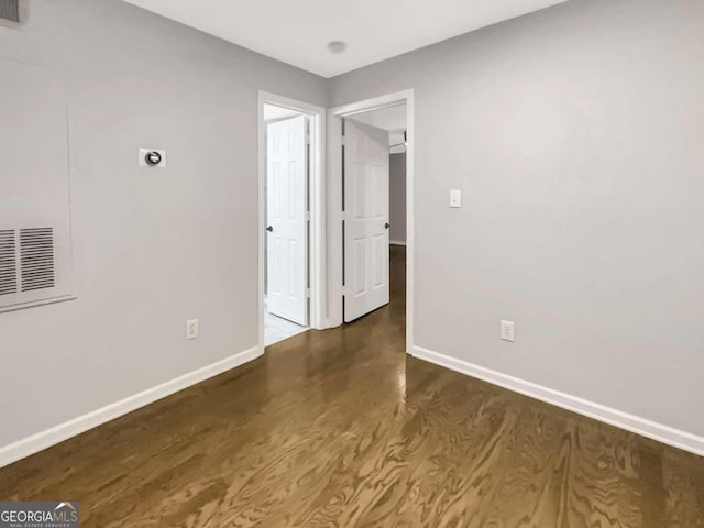 spare room featuring dark wood-type flooring