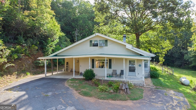 view of front of property with a front yard, covered porch, and a carport