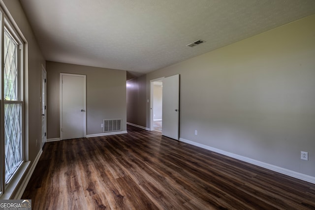 interior space with a textured ceiling and dark hardwood / wood-style floors