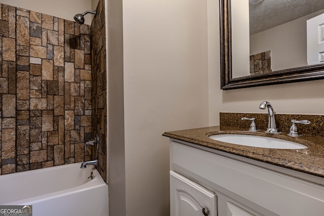 bathroom featuring a textured ceiling, vanity, and bathtub / shower combination