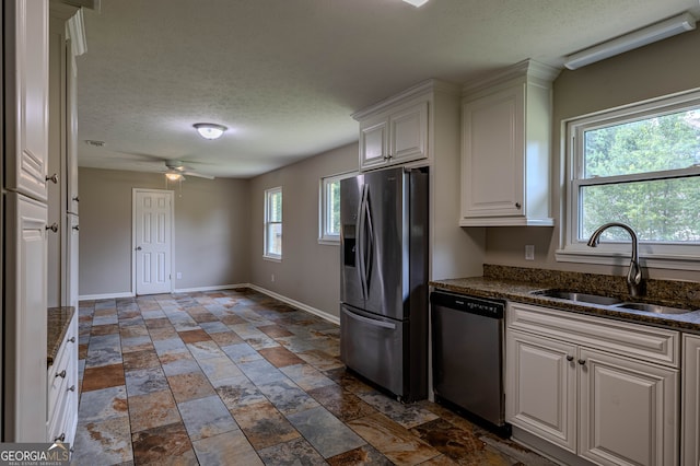 kitchen with ceiling fan, white cabinets, tile patterned floors, appliances with stainless steel finishes, and sink