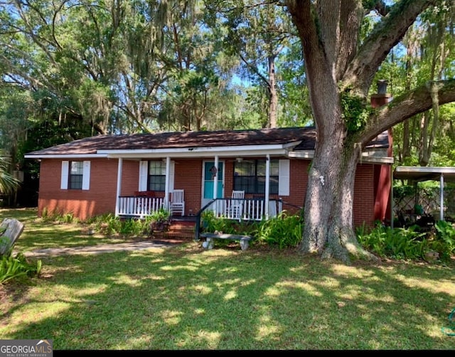 ranch-style home featuring a front lawn, a carport, and covered porch