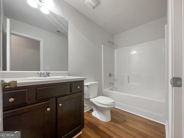 bathroom featuring shower / bathtub combination, toilet, wood finished floors, vanity, and visible vents