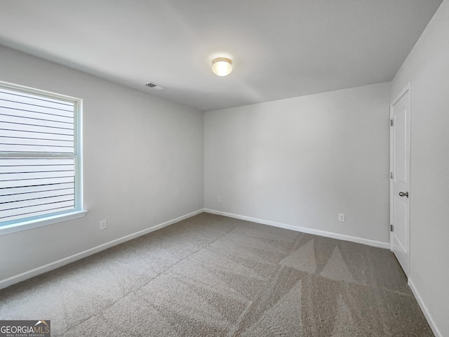 carpeted spare room with baseboards and visible vents