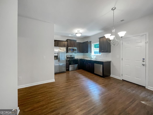 kitchen featuring dark wood-style floors, appliances with stainless steel finishes, light countertops, and dark brown cabinets