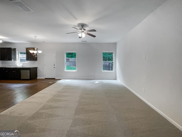 unfurnished living room featuring baseboards, visible vents, and a wealth of natural light